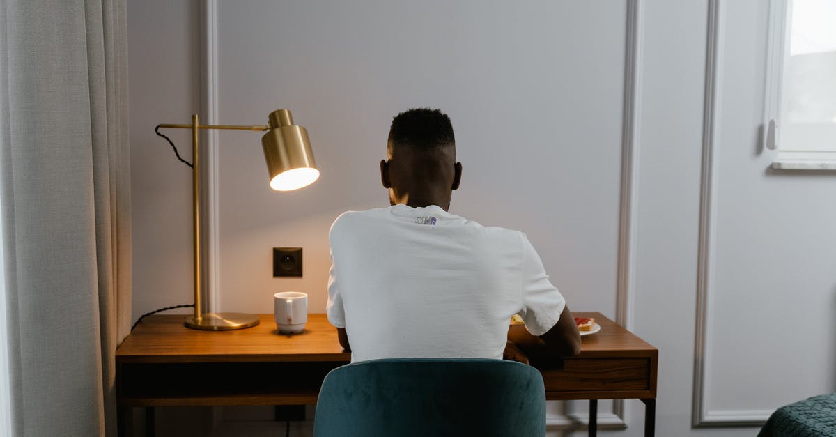 A person sitting at a desk in front of a mirror