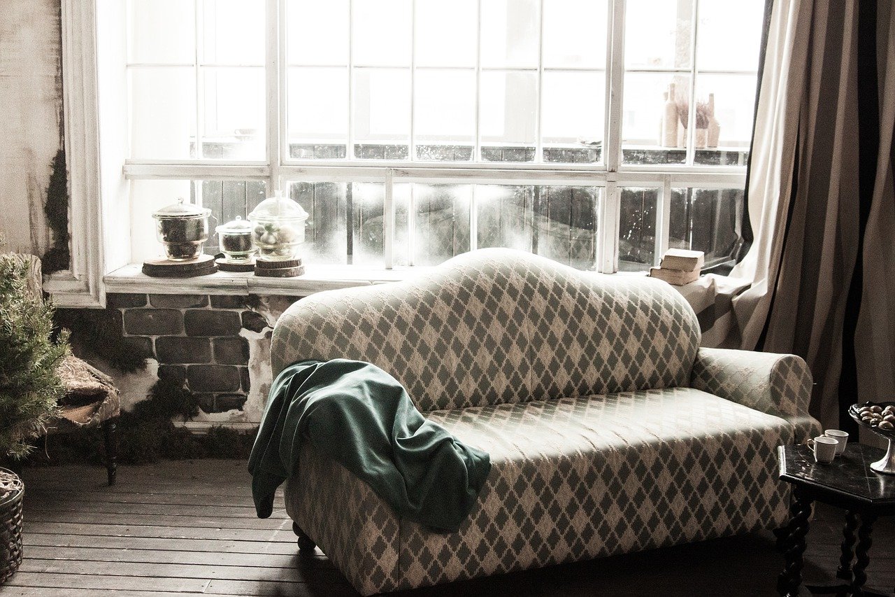 A living room with a bed and a window